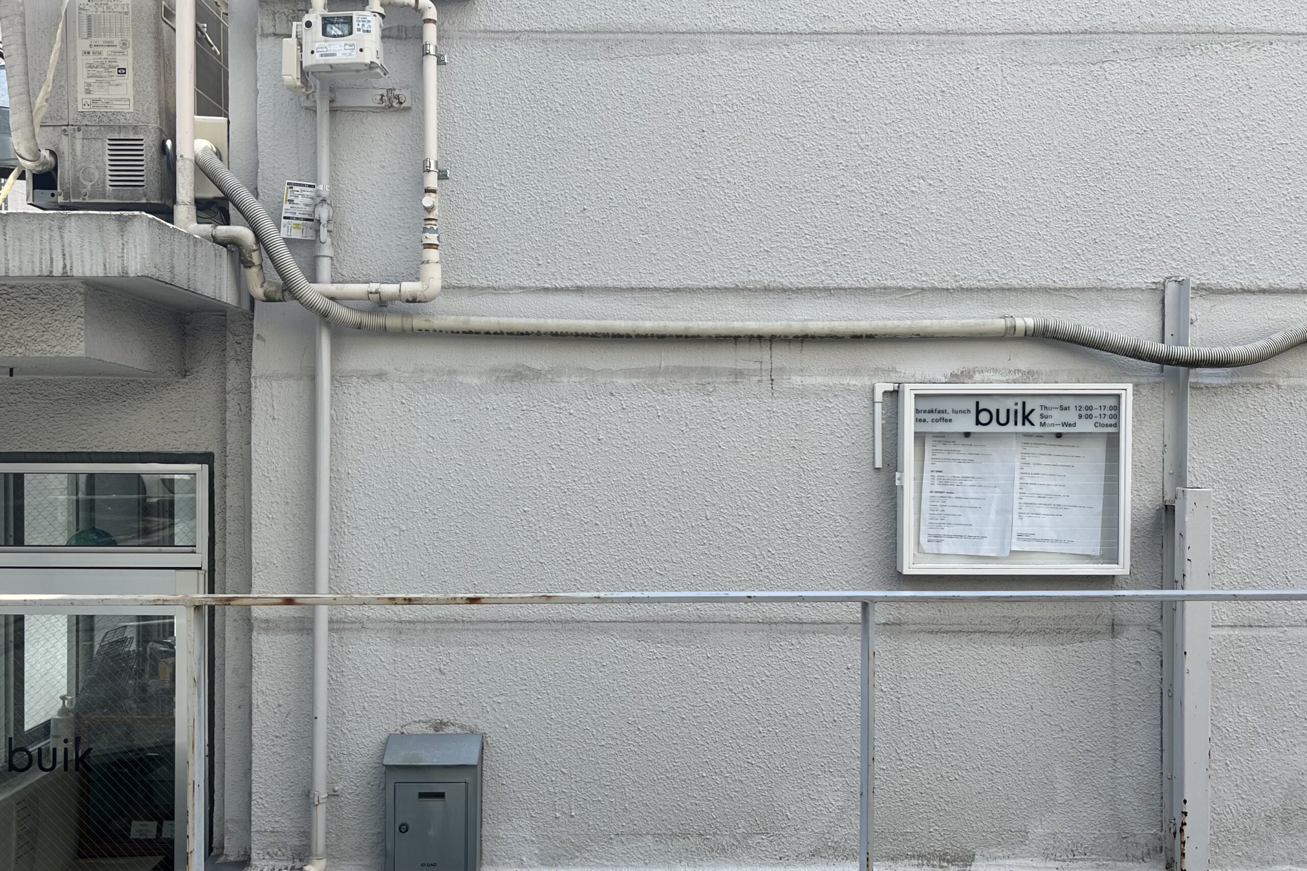 The exterior of Buik cafe in Aoyama, Tokyo, with its menu board on the wall